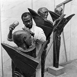 Ben Enwonwu seen here at work on the group of wooden figures that will stand in