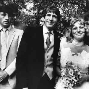 Bride Jackie Manders receiving a kiss from Aston Villa player Peter Withe watched by