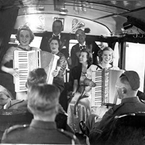 British army soldiers enjoy a performance from girls playing accordions at their mobile