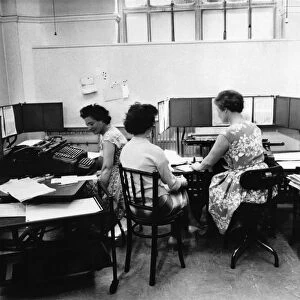 Cashiers calculating tax on wages. June 1960 P009077
