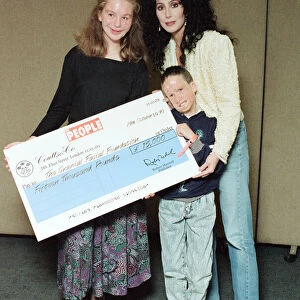 Cher, American singer, presents cheque for 15, 000 pounds to representatives of
