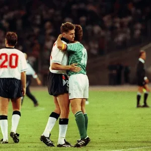 Chris Waddle Football is consoled and embraced by Lothar Matthaus of W Germany after