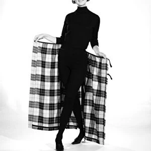 Clothing: Fashion: Skirts: Woman wearing tartan kilt. Model: Pamela Rowe. 1964 B1843-001