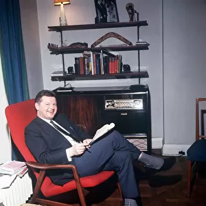The comic actor Benny Hill in his Kensington flat February 1966 reading in