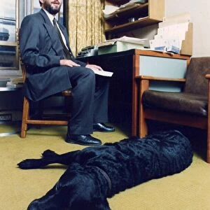 David Blunkett sitting inside his House of Commons office with his guide dog