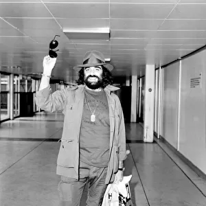 Demis Roussos leaving Heathrow Airport for Abu Dhabi. He is with a show