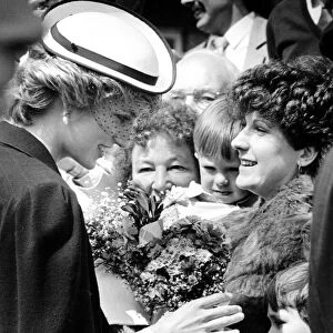 Diana, Princes of Wales receives a bouquet from an adoring well-wisher in the crowd