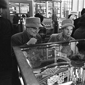 Two elderly ladies seen here caught up in the excitement of playing the slot machines at