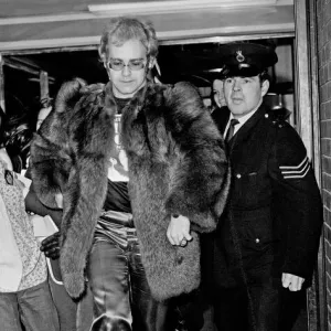 Elton John arrives at Heathrow Airport, and has to run from the crowds of fans who are