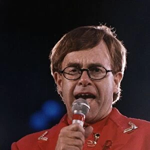 Elton John circa 1992 Wearing Red Suit as he holds microphone during a Freddie