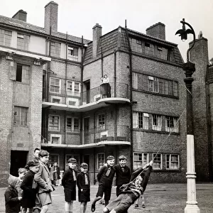 Evacuees returning from Leicestershire play in the street outside their tenement block in