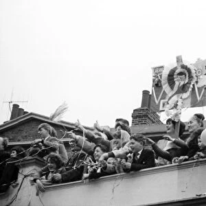 Fans of Tottenham Hotspur wave and cheer as their team arrive home after defeating