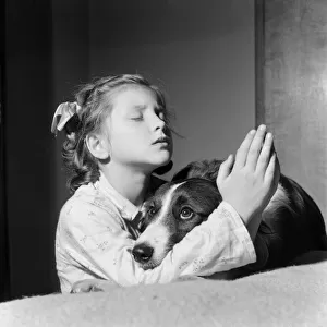 A girl and dog praying. 21st December 1954