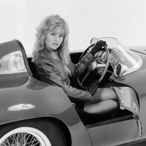 Glamour model Caroline Delahunty poses sitting in the drivers seat of a Ferrari