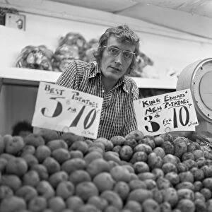 Greengrocer and his fruit and veg stall in Staffords indoor market. Circa June 1974