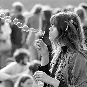 A hippy girl blowing bubbles at a pop concert in Hyde park, London June 1969