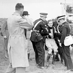 Injured jockey R Curran (Ulster Monarch) is helped to his feet in The Grand National