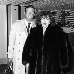 Joan Collins and Roger Moore at Heathrow airport, July 1988