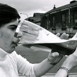 Joe Bailey drinking from a giant glass boot that he bought in Germany that holds 4 1 / 2