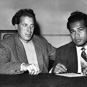 Kitione Lave (Right) and just Burton Sign the contract for their fight. September 1958
