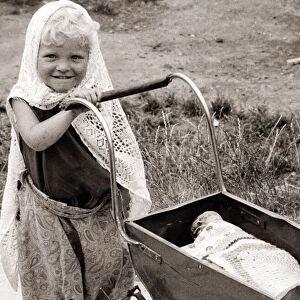 Little girl with doll pram, circa 1950