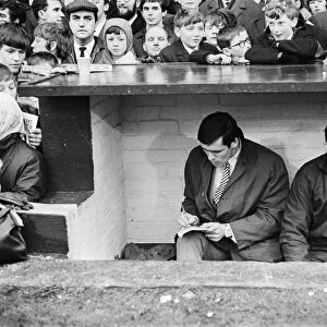 Liverpool footballer Tony Hateley in the dugout with trainer Bob Paisley as he sits out