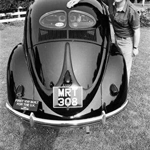 A man poses with a Volkswagen Beetle. 2nd June 1982