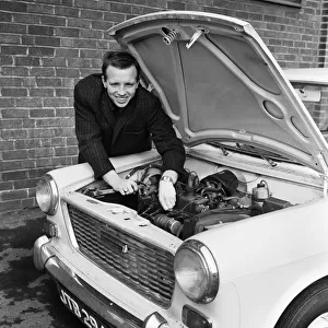 Manchester United and England footballer Nobby Stiles tends to his car engine at Old