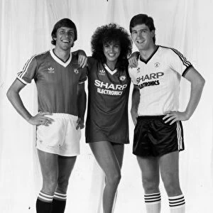 Manchester United footballers Arnold Muhren (left) and Norman Whiteside pose with model