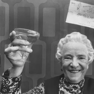 May Fyfe celebrates a pools win with a glass of champers, October 1976