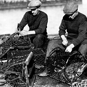 Mending their nets - Amble fishermen repairing their crab pots on the pier
