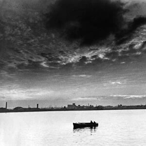 The Mersey Millpond. As night draws in, a lonely boat makes its way along a peaceful