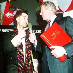 Michael Aspel TV Presenter of This is your Life surprising Nigel Kennedy holding red book