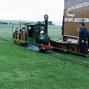 A miniature railway train. belonging to The Pilgrim Steam Railway Company with passengers