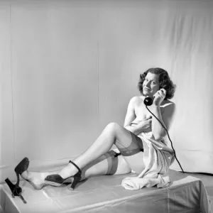 Mujer que lleva medias vista aquí en el teléfono. 1959 Mujer que lleva medias vista aquí en el teléfono. 1959