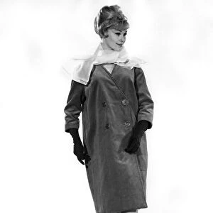 Model Jo Waring wearing a three quarter length buttoned coat with full length gloves