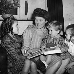 Mother reads a bedtime story to the children. December 1944 P010088