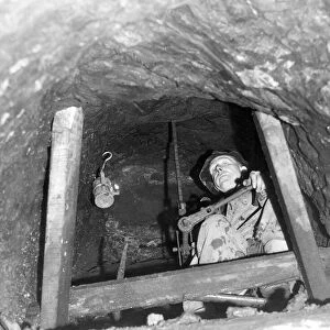 Mr. Edwin Rutherford, 58, is seen using a hand drill in a vertical tunnel 20 feet above