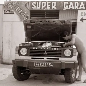 Naturist Nudist Village - July 1987 naked man working on a vehicle in the garage