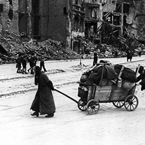 An old woman and her husband trundle through the Leipzig Strasse of Berlin