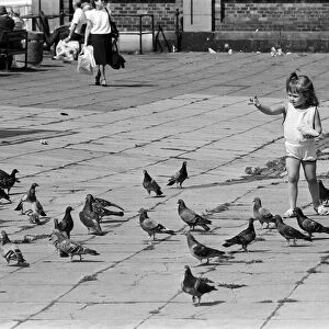 Pier Head, Liverpool, Merseyside, 17th August 1988. Young child plays with pigeons