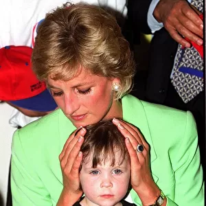 Princess Diana sitting with Caitlin Hines on her lap during a visit to a children