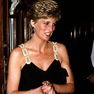 Princess Diana wearing a black low cut dress as she arrives at the London Coliseum
