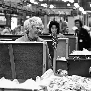 Queen Elizabeth II pauses to talk to one of the women on the assembly line during her
