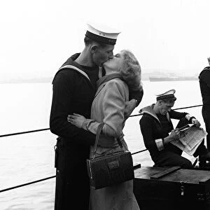 A sailor kisses his girlfriend as the HMS Black Swan returns to England