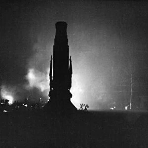 The silhouette of The Cenotaph, Whitehall, London. Flamed billow behind it