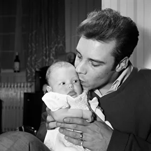 Singer Marty Wilde at home in Chiswick with his baby daughter Kim. 30th January 1961