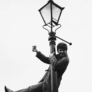 Stephanie Powers Actress hanging on lamp post with drink in hand Circa 1970