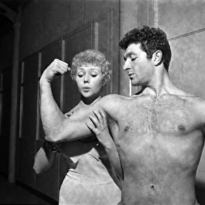 Strong man of Television Arthur Mason showing of his muscles to girlfriend Vera Day