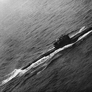 A surrendered German U-boat in the English channel heads to an Allied port under guard